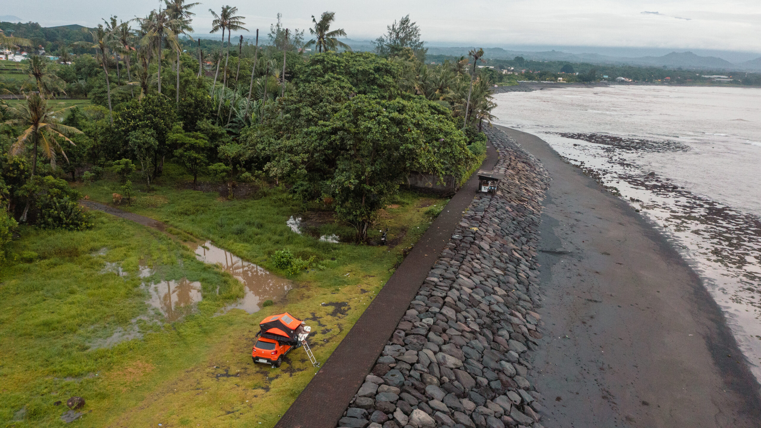Camper parked by the seawall at dawn